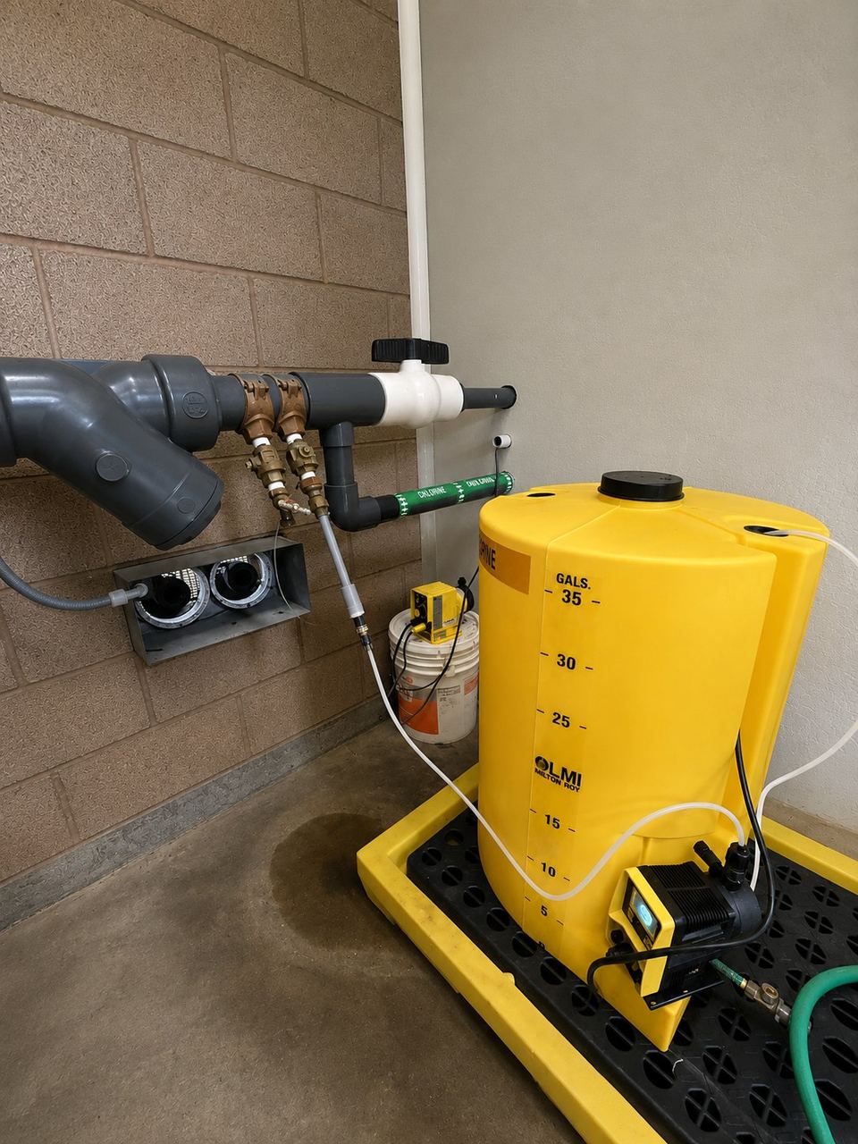 Chemical feed tank and pump plumbed to a pump-house wall