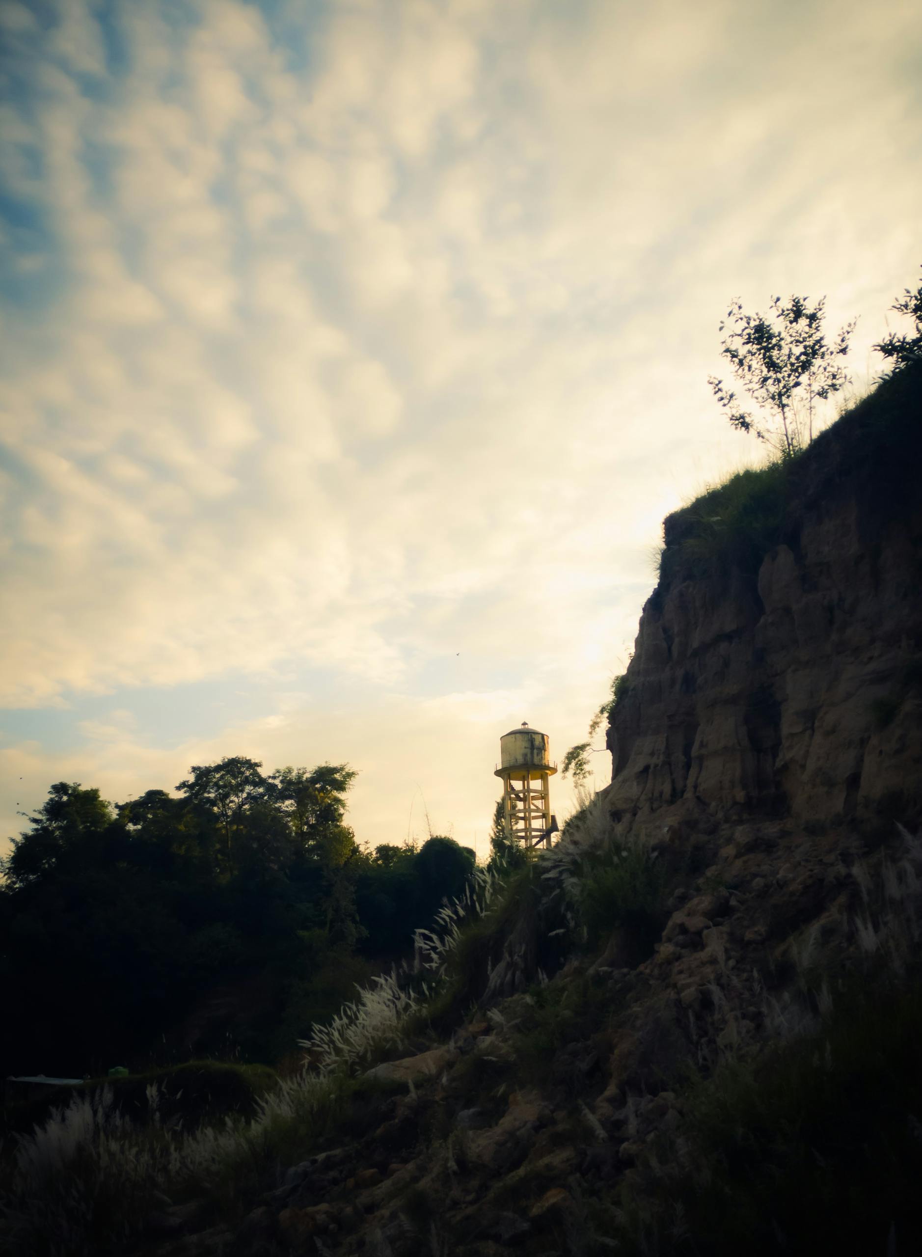 Water tower surrounded by cliffs at sunset, representing storage tank inspection