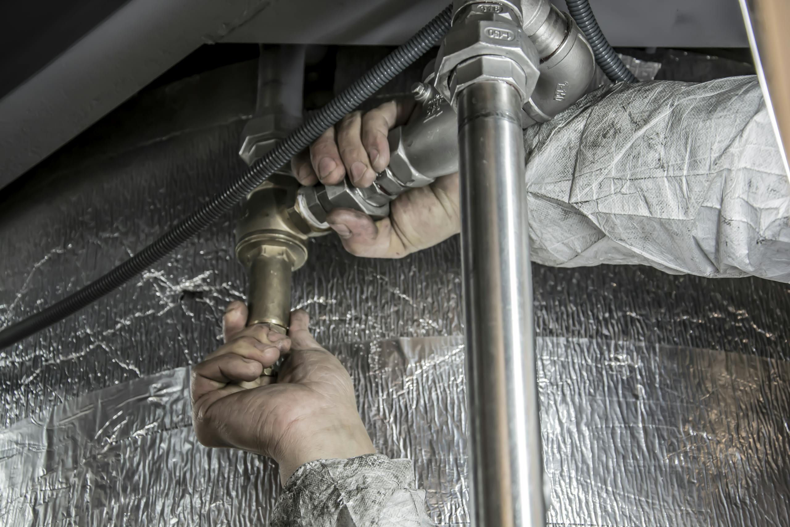 Close-up of hands installing steel water pipes for a distribution system